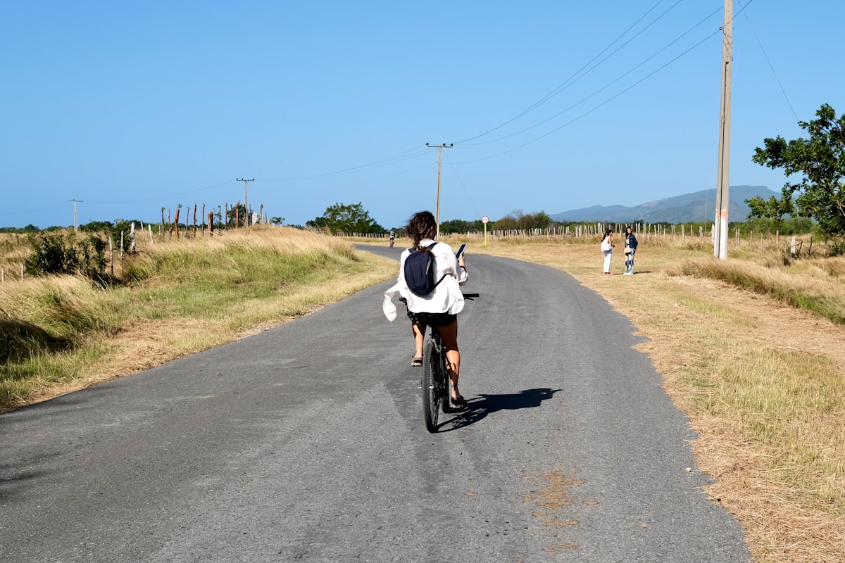田舎道を自転車で走る人 – 自由に動ける旅のかたち